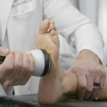 StemWave treatment on bottom of patient's foot for foot pain relief.